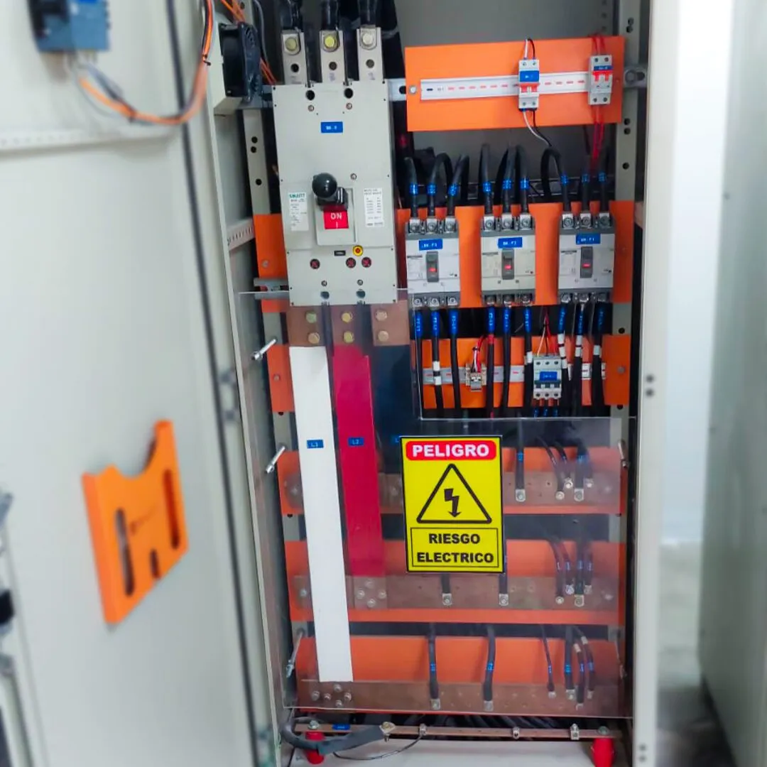 Tablero de control abierto con protecciones y señalización de riesgo eléctrico